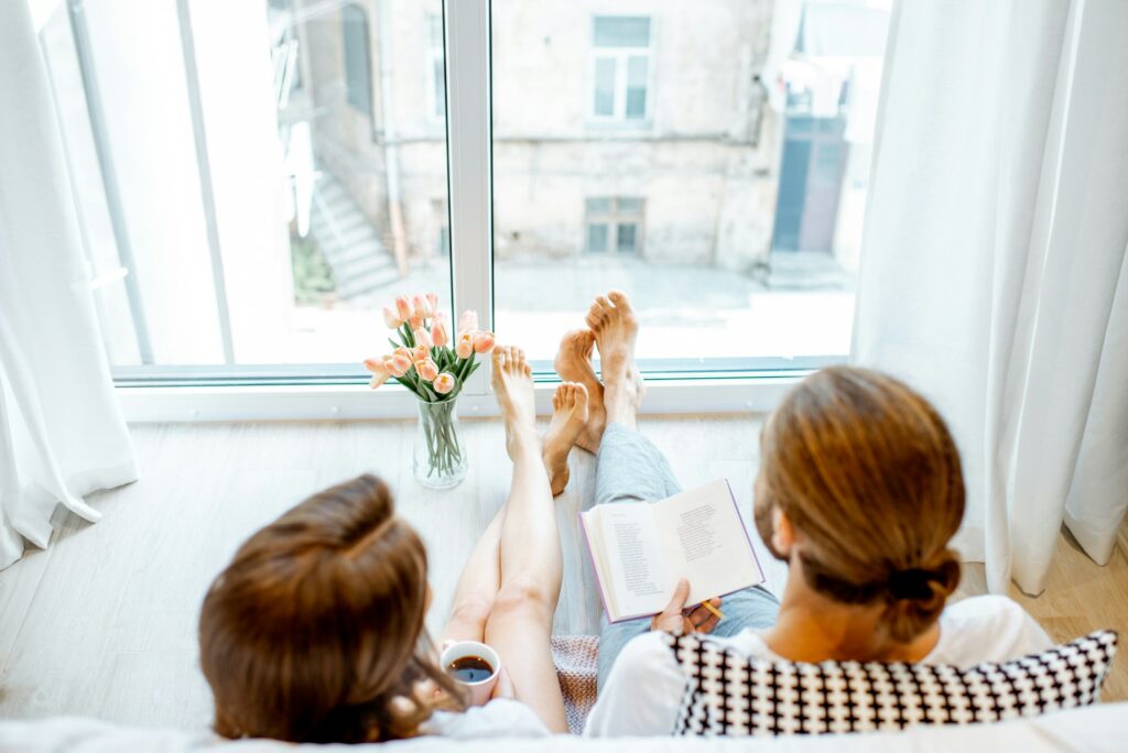 Couple relaxing in the bedroom at home, feet over clean door and windowsills