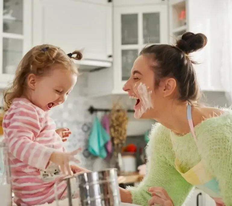 Mother and young child smiling together in a bright kitchen in Austin