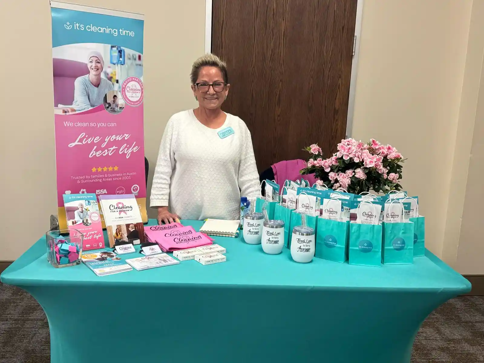 Team member standing behind a branded event table at a business event in Austin
