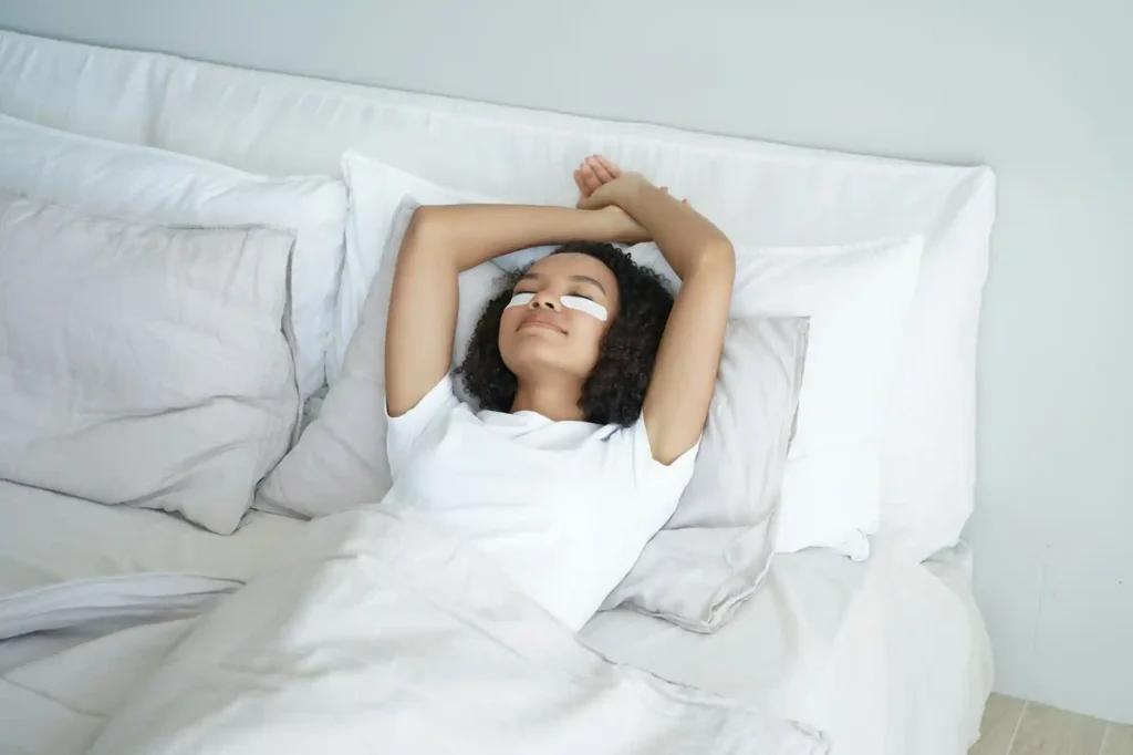 Woman relaxing in a neatly made bed in a clean bedroom in Austin