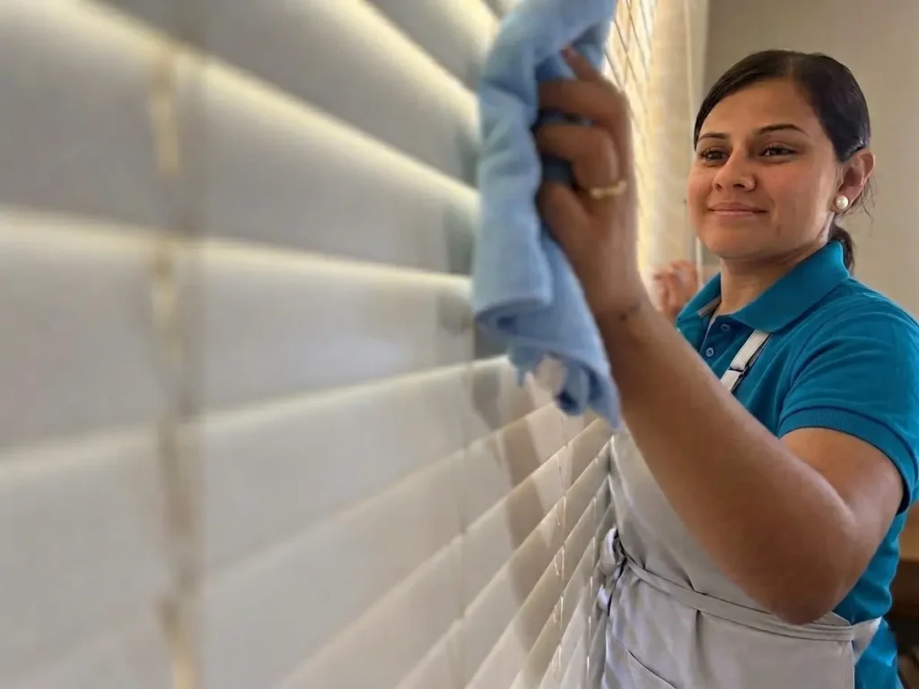 House cleaner wiping tile wall during detailed home cleaning service in Austin TX