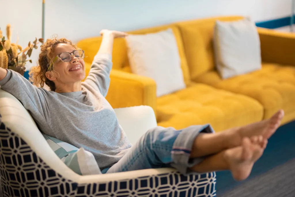 Woman relaxing in a clean living room chair after house cleaning in Austin