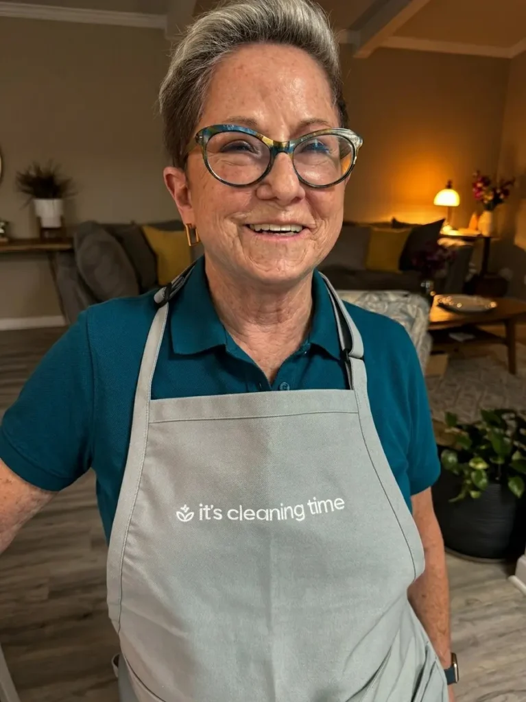 Professional house cleaner smiling in uniform inside a clean modern home in Austin TX