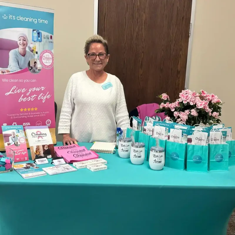 Team member standing behind a branded event table at a business event in Austin